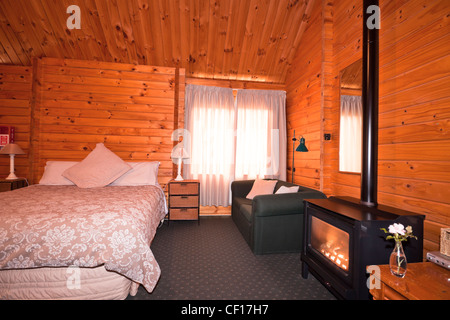 Lodge bedroom interior with fireplace. Fox Glacier Lodge, Fox Glacier, West Coast, South Island, New Zealand. Stock Photo