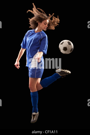 Caucasian soccer player kicking ball Stock Photo