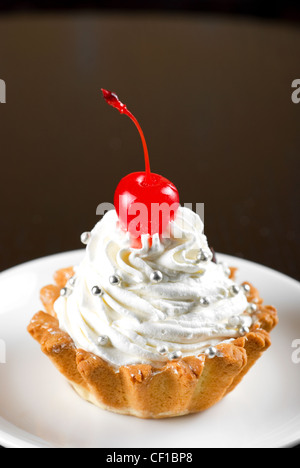 fresh baked cherry cupcake on a dark wooden background Stock Photo