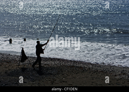 An angler fishing from the beach at Tywyn, a seaside resort on Cardigan Bay. Stock Photo