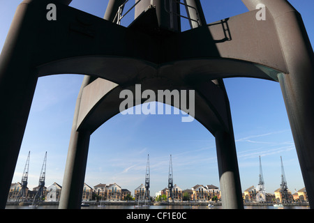 Derelict cranes stand as a reminder of the past at Royal Victoria Dock in the redeveloped Docklands area of London 7. Stock Photo