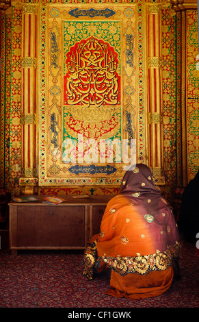 A  muslim woman praying in front of  the Mausoleum of the Sufi saint Nizamuddin Auliya (Nizamuddin Dargah), Delhi, India Stock Photo