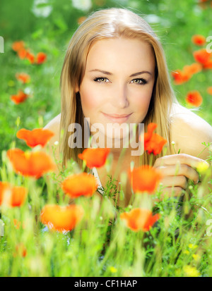 Young beautiful girl enjoying on the poppy flowers field, outdoor portrait, summer fun concept, beautiful woman relaxing Stock Photo