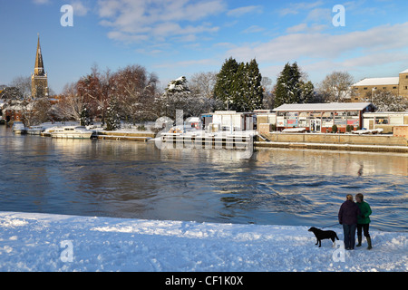 Two women talking on the snow covered path by the River Thames at Abingdon. Stock Photo