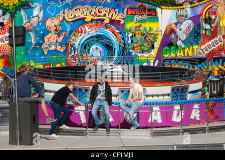 Carnies at sitting on railings by a ride at Abingdon Fair. Stock Photo