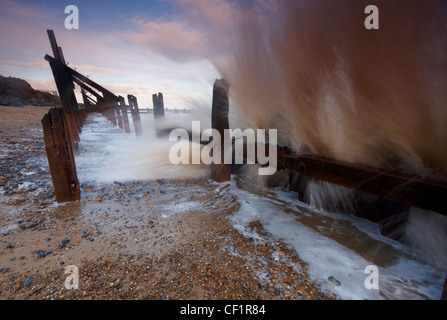 A wave breaking over coastal defences at Happisburgh on the Norfolk coast. Stock Photo