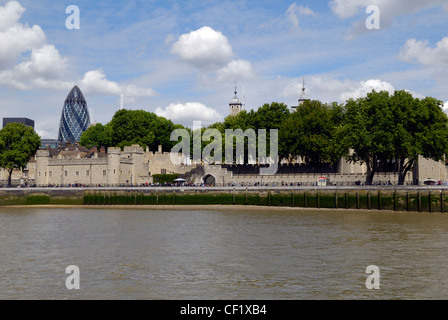 Two of London's iconic landmarks new and old. The Swiss Re Tower (Gherkin) and the Tower of London viewed from a boat on the riv Stock Photo