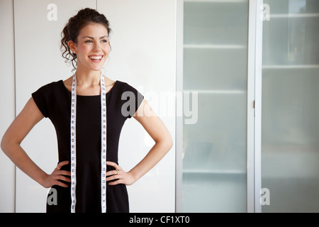 Businesswoman with measuring tape around her neck Stock Photo