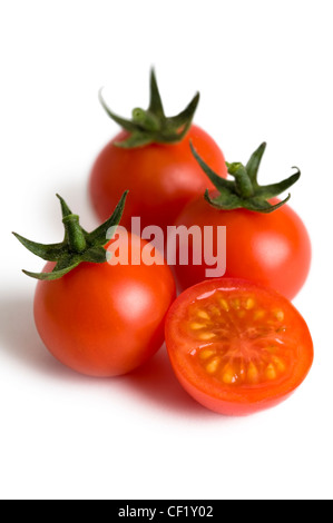 cherry tomatoes isolated with one tomato cut in half Stock Photo