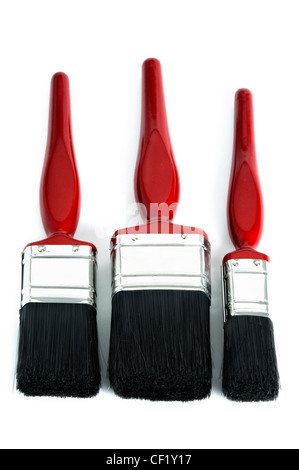 three red paintbrushes of different sizes isolated on a white background Stock Photo