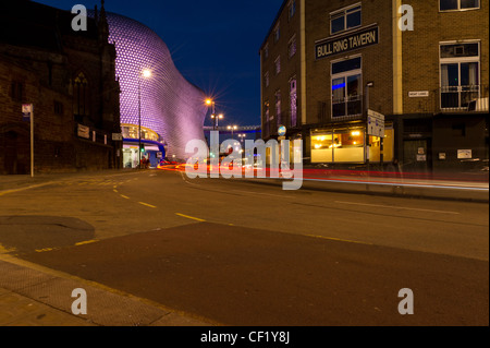 a night scene of the bull ring tavern with selfridges in the background and car lights streaking past Stock Photo