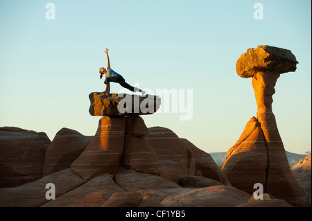 Caucasian woman practicing yoga on top of rock formation Stock Photo