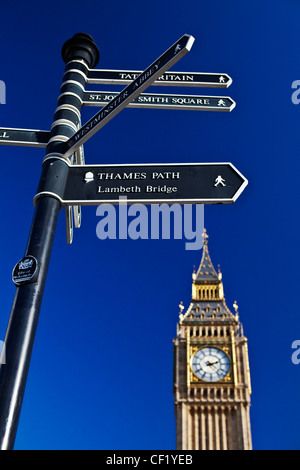Big Ben towering over a directional signpost pointing the way to the nearby tourist attractions. Stock Photo
