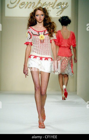 Temperley London Ready To Wear Spring Summer Model Lily Cole big curly red hair wearing white shorts and crochet top strappy Stock Photo