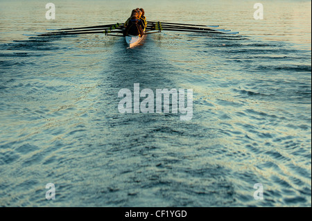 Team rowing boat in bay Stock Photo