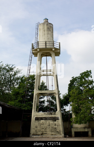 Old abandoned industrial water tower with reservoir tank in factory Stock Photo