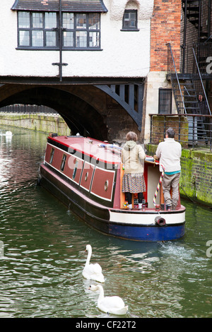 River barge heading under 16th Century half-timbered building on the medieval High Bridge Witham, Fossdyke, Lincoln City Stock Photo