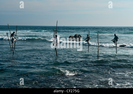 the stilt fishermen of southern Sri Lanka perched on their poles above the Indian Ocean Stock Photo