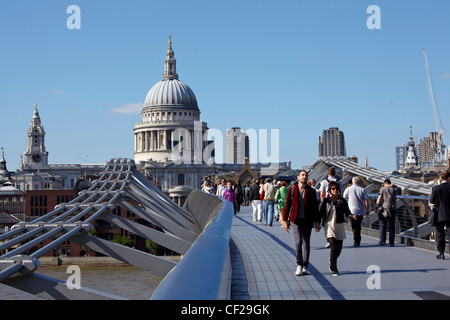 People crossing the Millennium Bridge over the River Thames connecting St Pauls Cathedral on the north bank to Bankside on the s Stock Photo