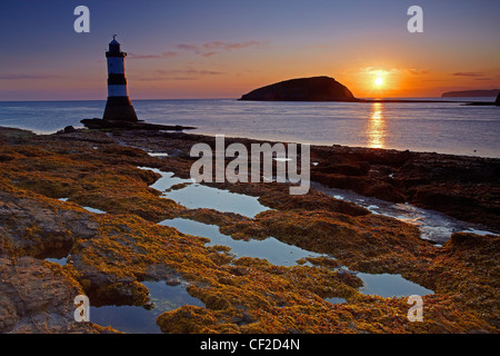Penmon Lighthouse, also known as Menai Lighthouse, at the north entrance to the Menai Strait opposite Puffin Island at sunrise. Stock Photo