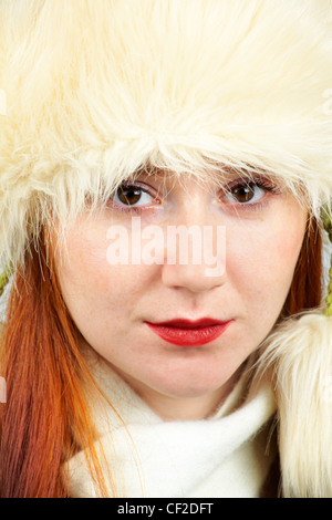 Headshot of an elegant 20 year old redhead wearing a furry hat. Stock Photo