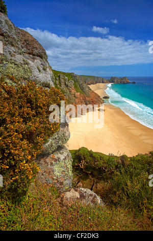 View down from the clifftop to the golden sand and turquoise sea at Pednvounder beach with Treen Cliffs and Logan Rock in the di Stock Photo