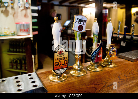 Beer pump handles on the bar at The Hoop, a freehouse which dates back 450 years. Stock Photo
