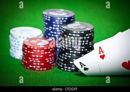 Gambling chips, ace of diamonds and king of spades on green poker cloth. Stock Photo