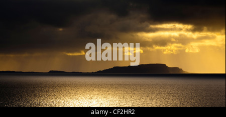 Dramatic shafts of light from the setting sun above the Isle of Soay, viewed from Elgol on the Isle of Skye. Stock Photo