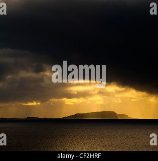 Dramatic shafts of light from the setting sun above the Isle of Soay, viewed from Elgol on the Isle of Skye. Stock Photo
