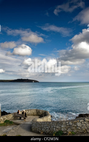 Two women sitting on a bench overlooking the entrance to Falmouth Harbour, the third deepest natural harbour in the world. Stock Photo