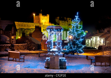 Christmas decorations in the village of Bamburgh with Bamburgh Castle, once the residence of the Kings of Northumbria, in the ba