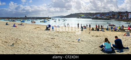 People relaxing on the sandy beach by St Ives Harbour. Stock Photo