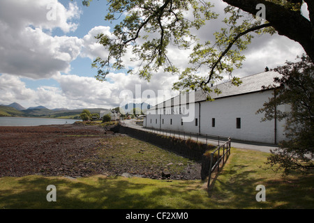 Talisker Whisky Distillery at Carbost on the shores of Loch Harport with dramatic views of the Cuillins on the Isle of Skye. Stock Photo