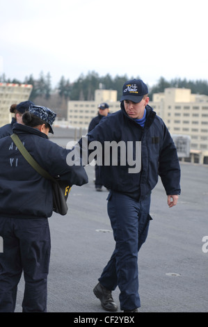 BREMERTON, Wash. (Feb. 28, 2012) – Sailors aboard the aircraft carrier USS Nimitz (CVN 68) take part in a foreign object debris (FOD) walk-down of the flight deck. FOD walk-downs ensure the safety of personnel and equipment while keeping Nimitz in a constant state of readiness to receive aircraft. Nimitz is making final preparations to return to sea. Stock Photo