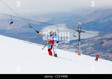 skiers on uplift button tow at nevis range fort william scottish Highlands UK during winter Stock Photo