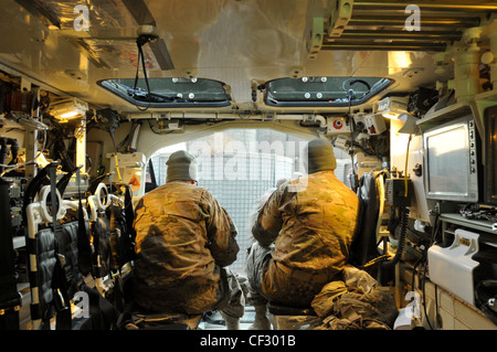 US Army Soldiers assigned to the Headquarters & Headquarters Company, Brigade Troops Battalion, 1st Stryker Brigade Combat Team, 25th Infantry Division, take a break after completing an early morning escort mission into COP Sperwan Ghar in Panjwa’i District, Kandahar Province, Afghanistan on Feb 27, 2012. Stock Photo