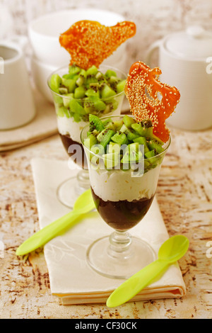 Cups with kiwifruit, plums and crusty sesame. Recipe available. Stock Photo