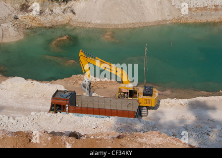 Downside Mining from Big Clay factory's Dig by Bulldozer and Truck.Water pond formed as the effect of Mining also on the frame. Stock Photo