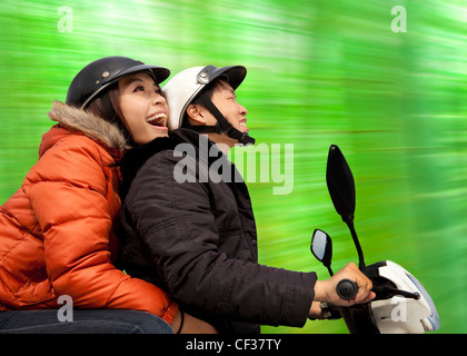 happy couple riding on the bike at spring time Stock Photo