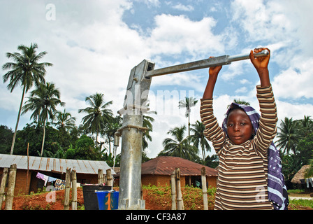 Girl collecting water from a UNDP-sponsored well in a village near Kenema, Sierra Leone Stock Photo