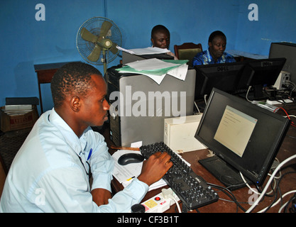 Staff use computers in a local government office in Kenema, Sierra Leone Stock Photo