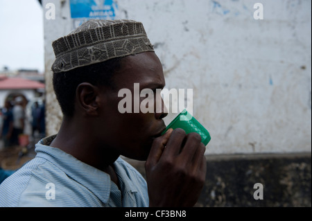 Man drinking tea from a plastic cup Stone Town Zanzibar Tanzania Stock Photo