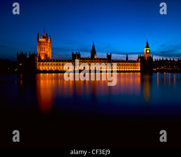 View across the River Thames to an illuminated Houses of Parliament. Stock Photo