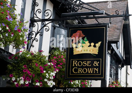 Hanging baskets next to a pub sign for the Rose and Crown in Stratford upon Avon. Stock Photo