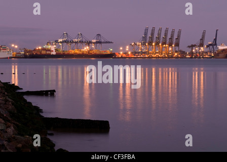 A view towards an illuminated Harwich docks from Shotley Gate at sunset. Stock Photo