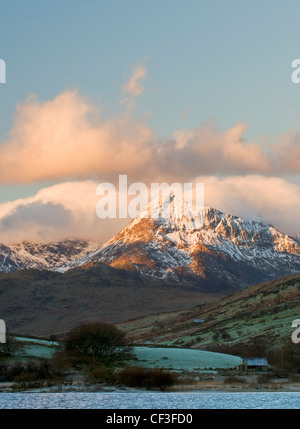 A view of pink clouds surrounding the peak of Mount Snowdon from Capel Curig. Stock Photo