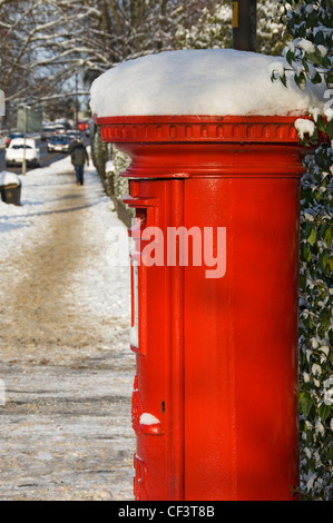 Traditional red post box in winter. Stock Photo