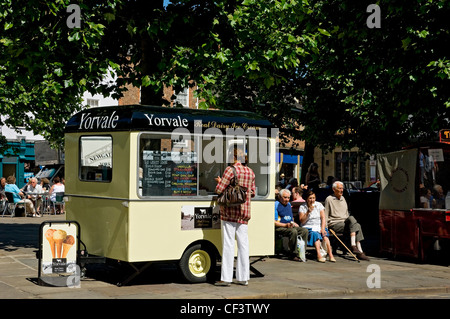 A woman buying an ice cream from a van in St Sampson's Square. Stock Photo