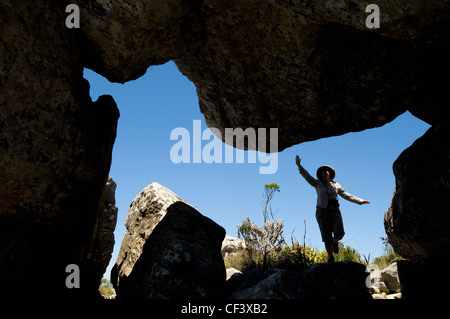 A hiker explores a cave in the Mountains near Cape Town Stock Photo